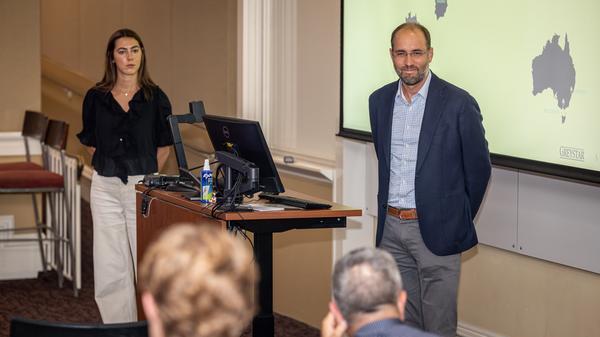 Man and woman standing at front of classroom giving presentation