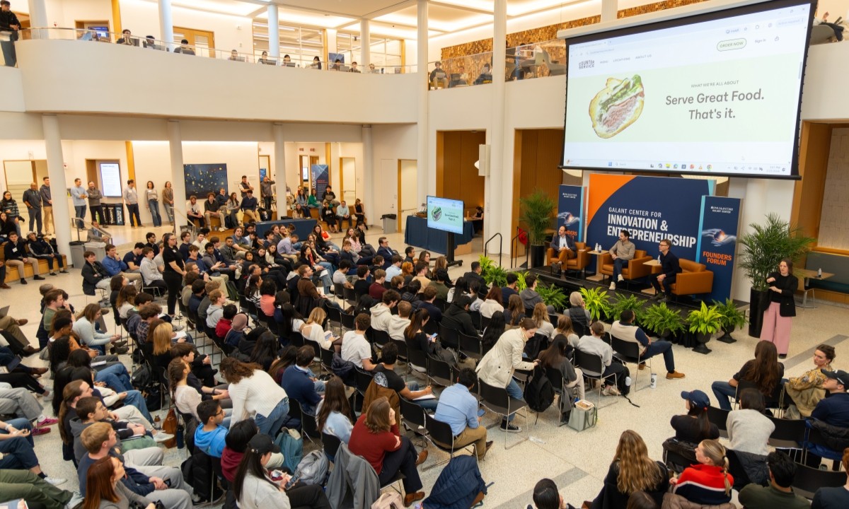 Founders Forum attendees watching a presentation in Shumway Hall's atrium