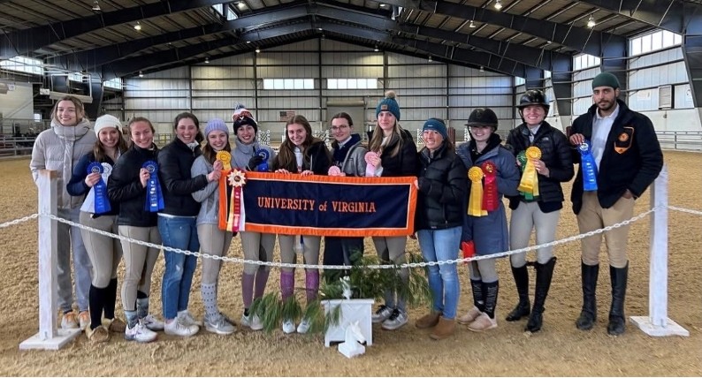 a group of people in riding gear standing side by side and smiling at the camera