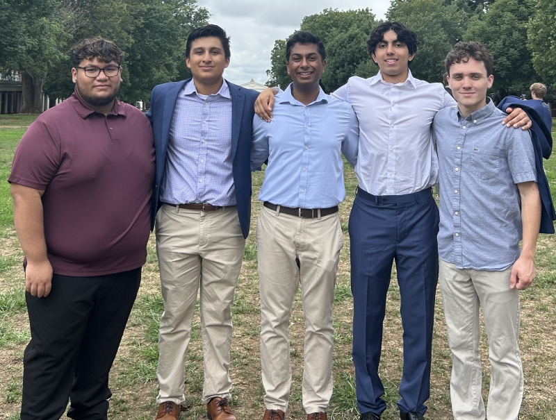 five students standing side by side on the UVA Lawn, smiling