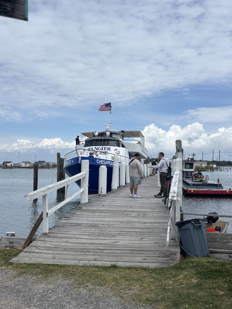 a boat at a dock, with two people standing on the dock
