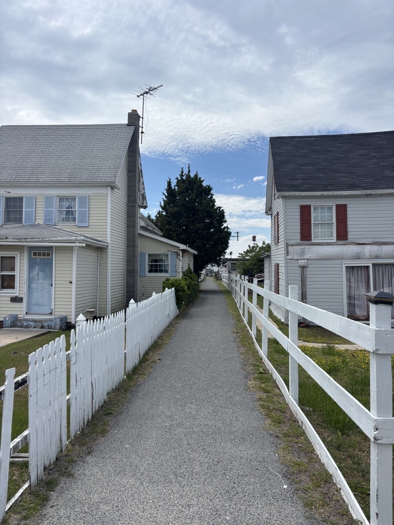a gravel pathway with houses on each side