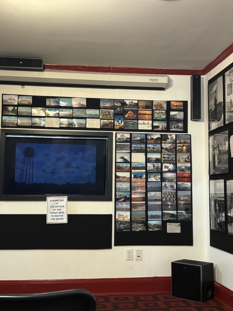a wall of postcards and a tv screen