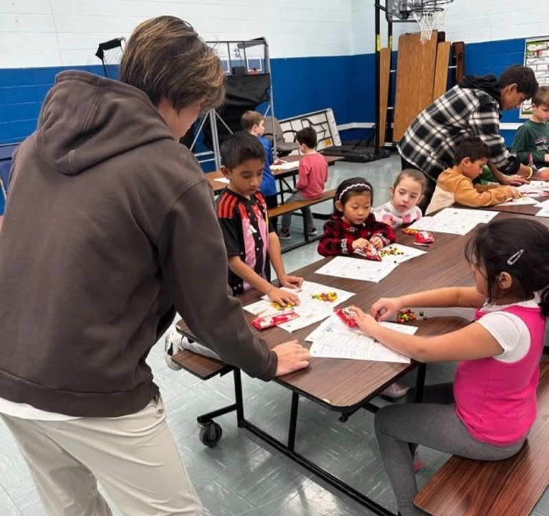 David Sun teaching students seated at a lunch table