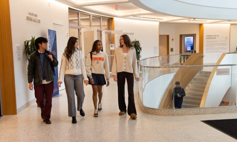 four students walking in a hallway