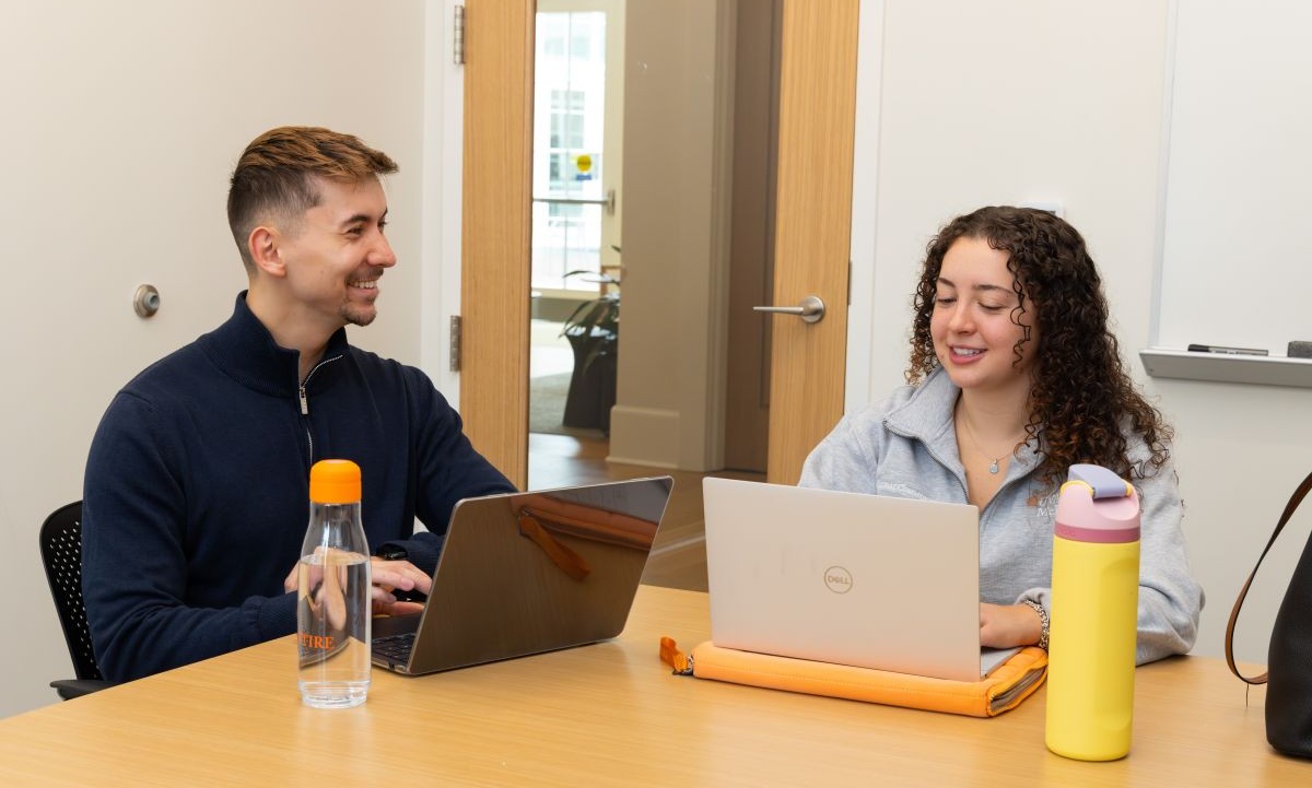 two students sitting at a table talking